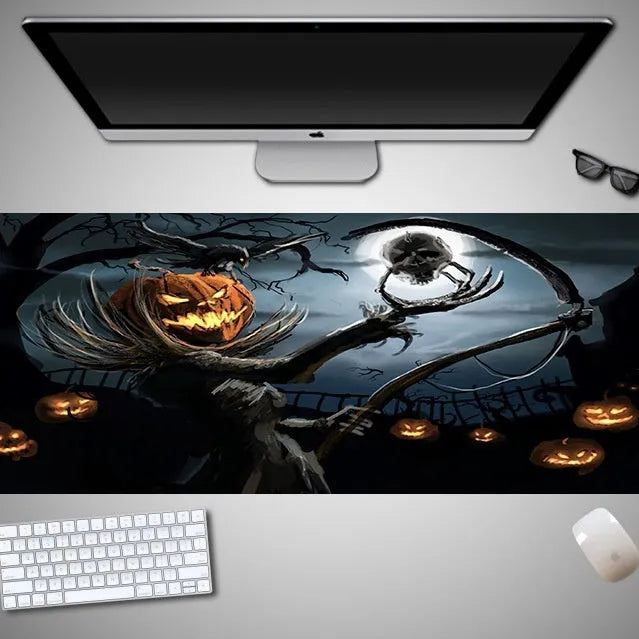 Oversized black Halloween-themed mouse pad with spooky artwork on a desk next to a gaming mouse.