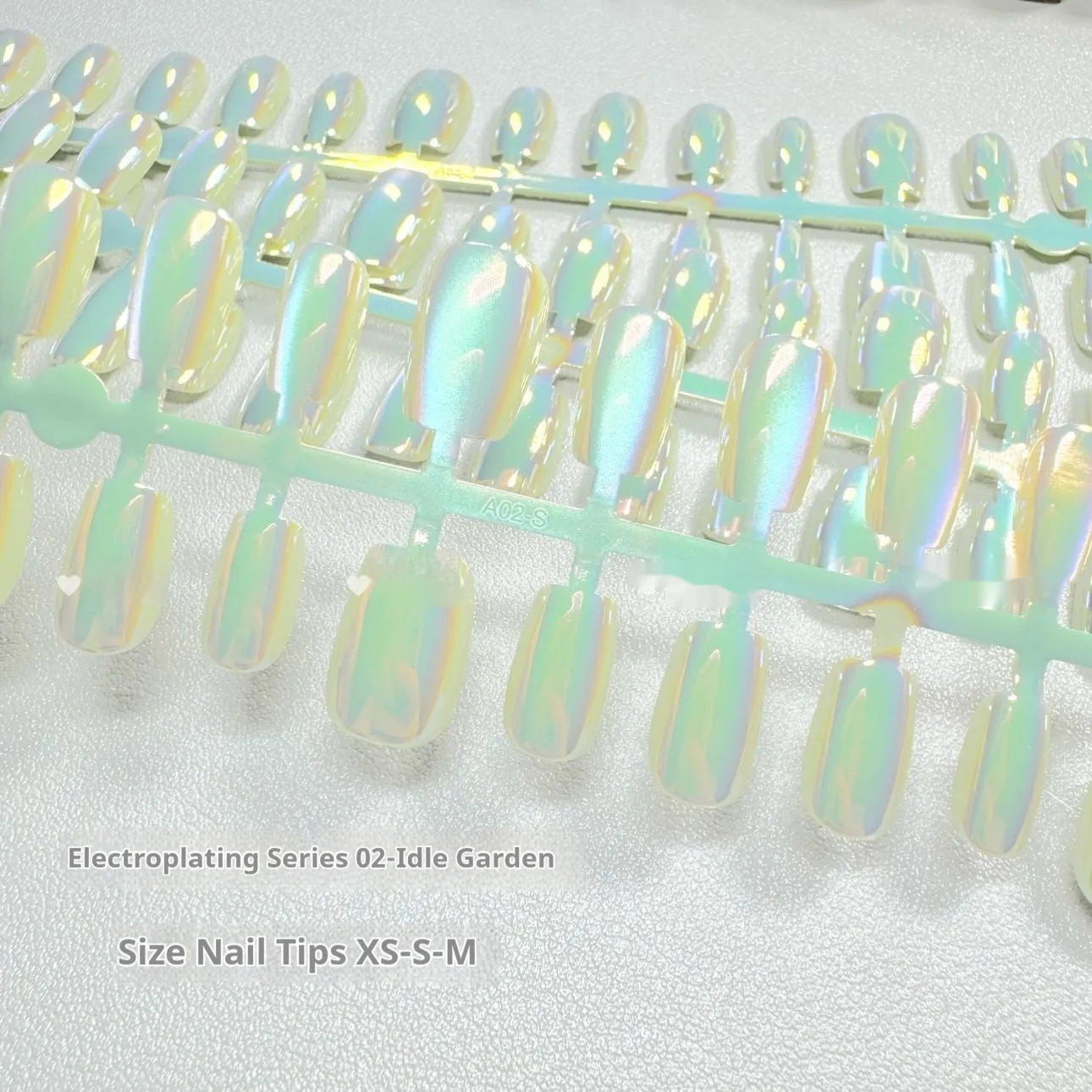 Electroplated Cat's Eye false nail wraps showing Aurora and solid colour designs in short ladder sizes XS, S, and M.