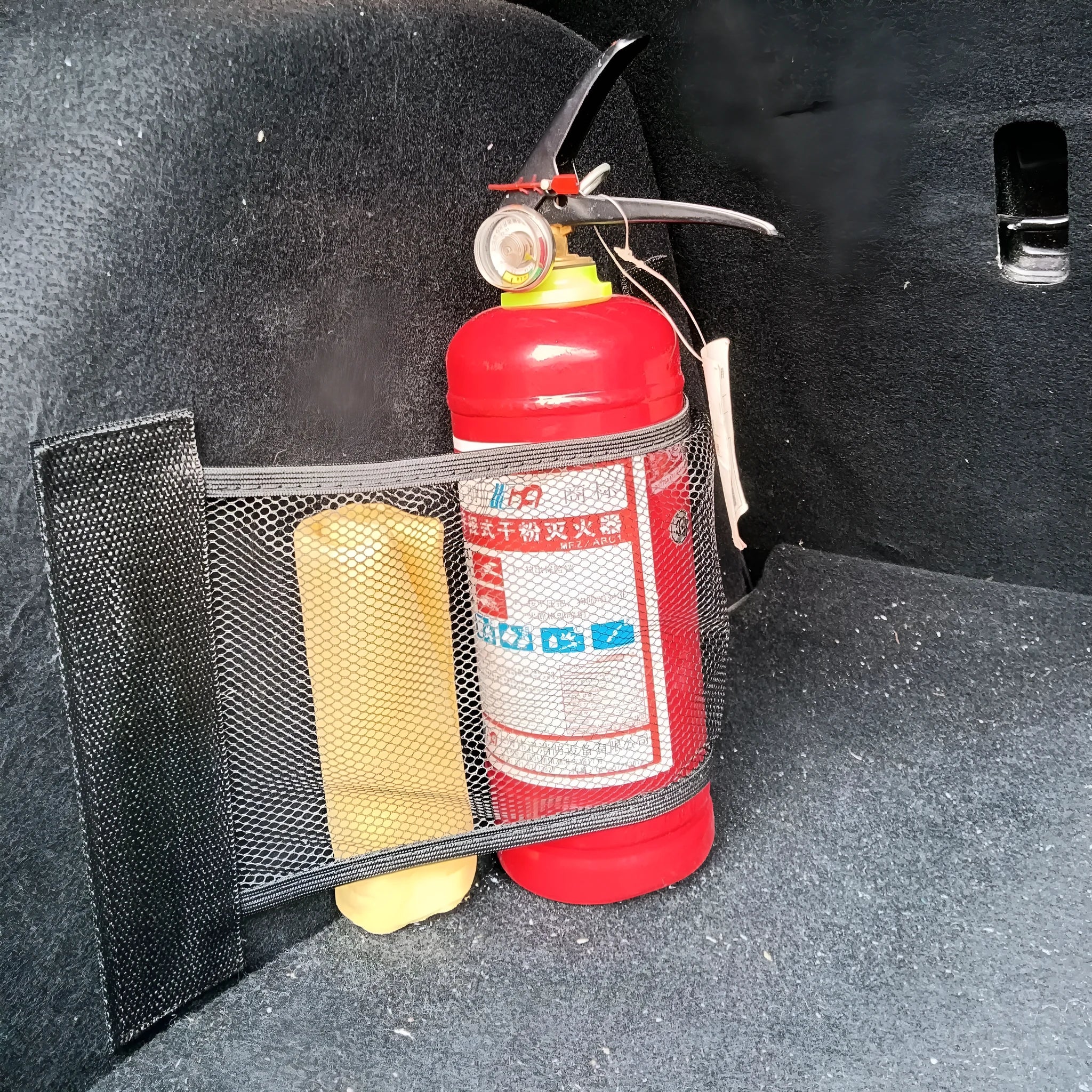 Car trunk elastic storage net organising loose items in vehicle boot