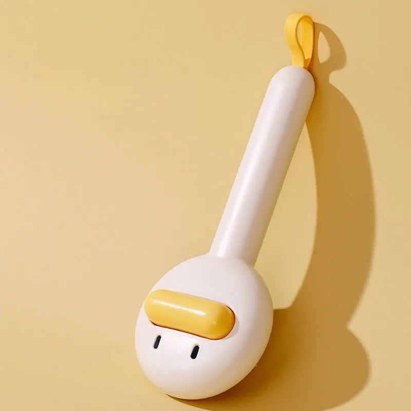 Small yellow plastic duck-shaped pet grooming comb with needle bristles.