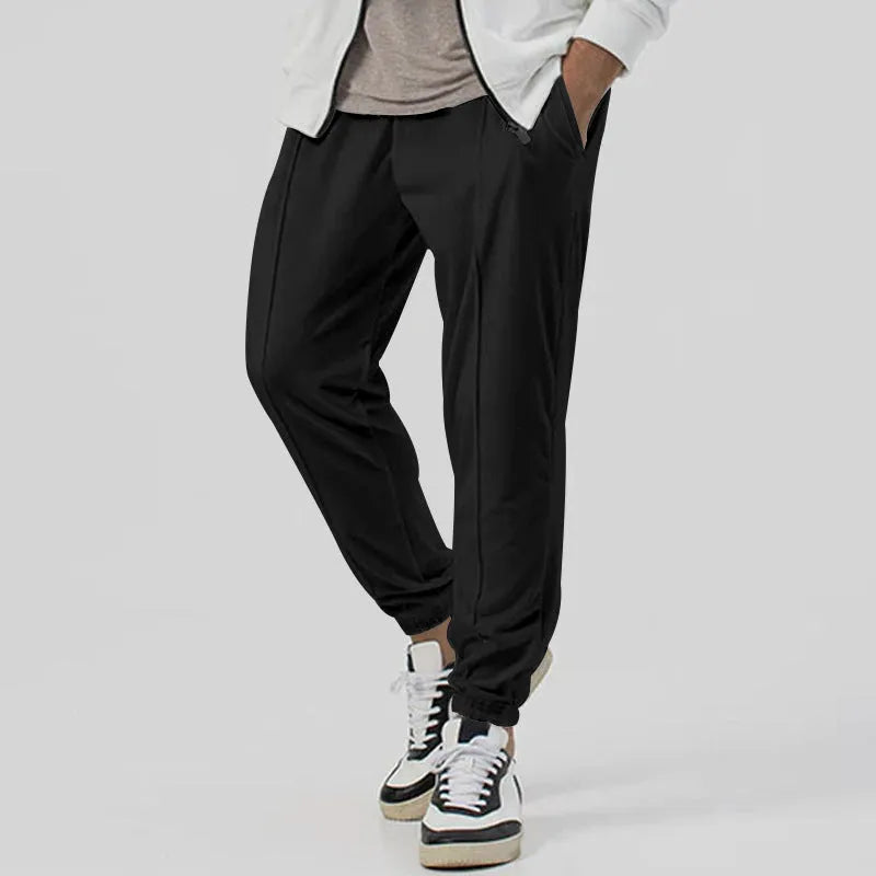 Men's grey loose tapered track sweatpants with elastic waist and straight leg design.