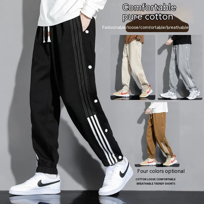 Men's black high-waist sweatpants with ankle-tied cuffs and a drawstring waist on a grey background.
