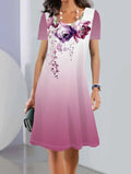 A model wearing a light blue botanical print midi dress with short sleeves and an A-line skirt.