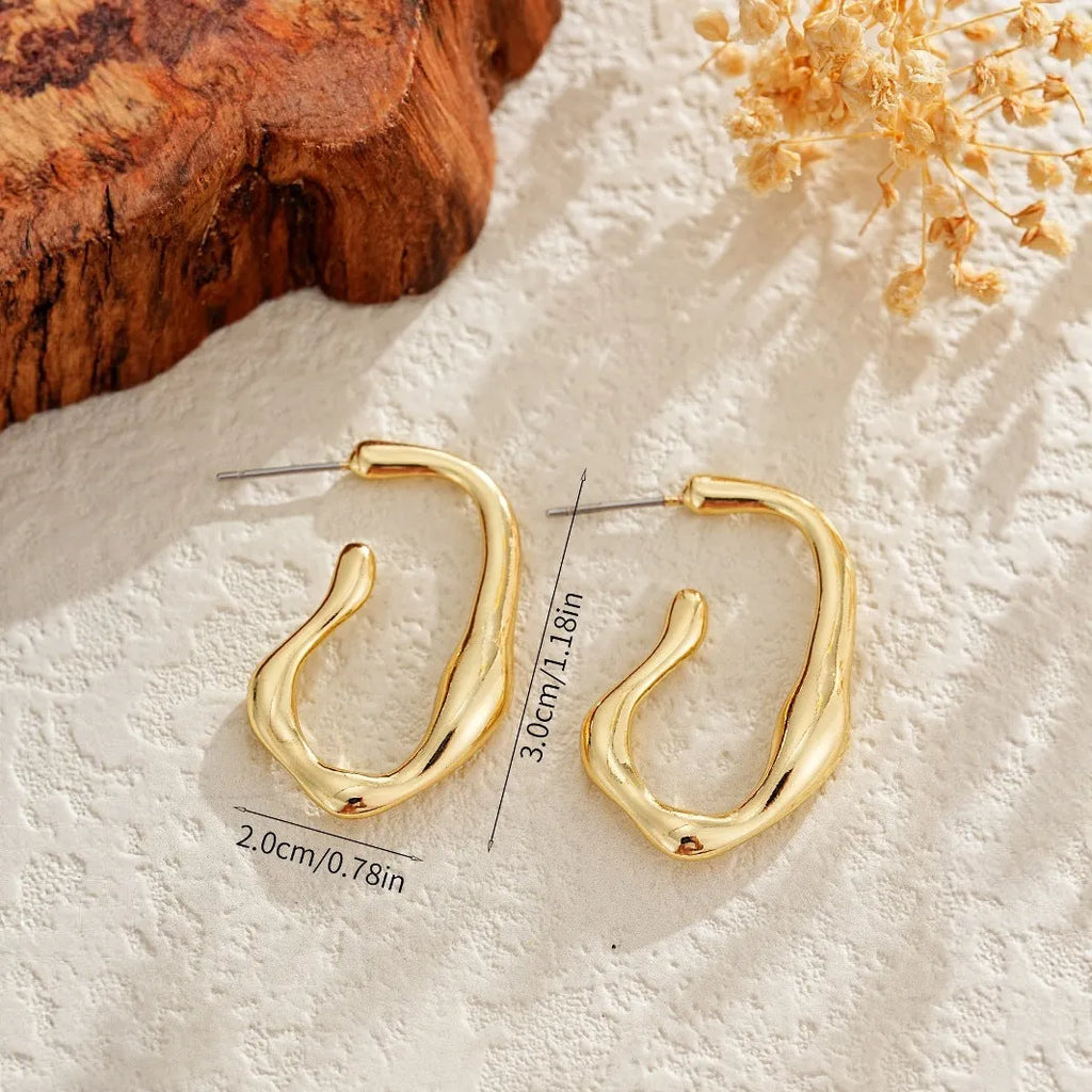 Irregular shaped minimalist gold dangle earrings for women on white background