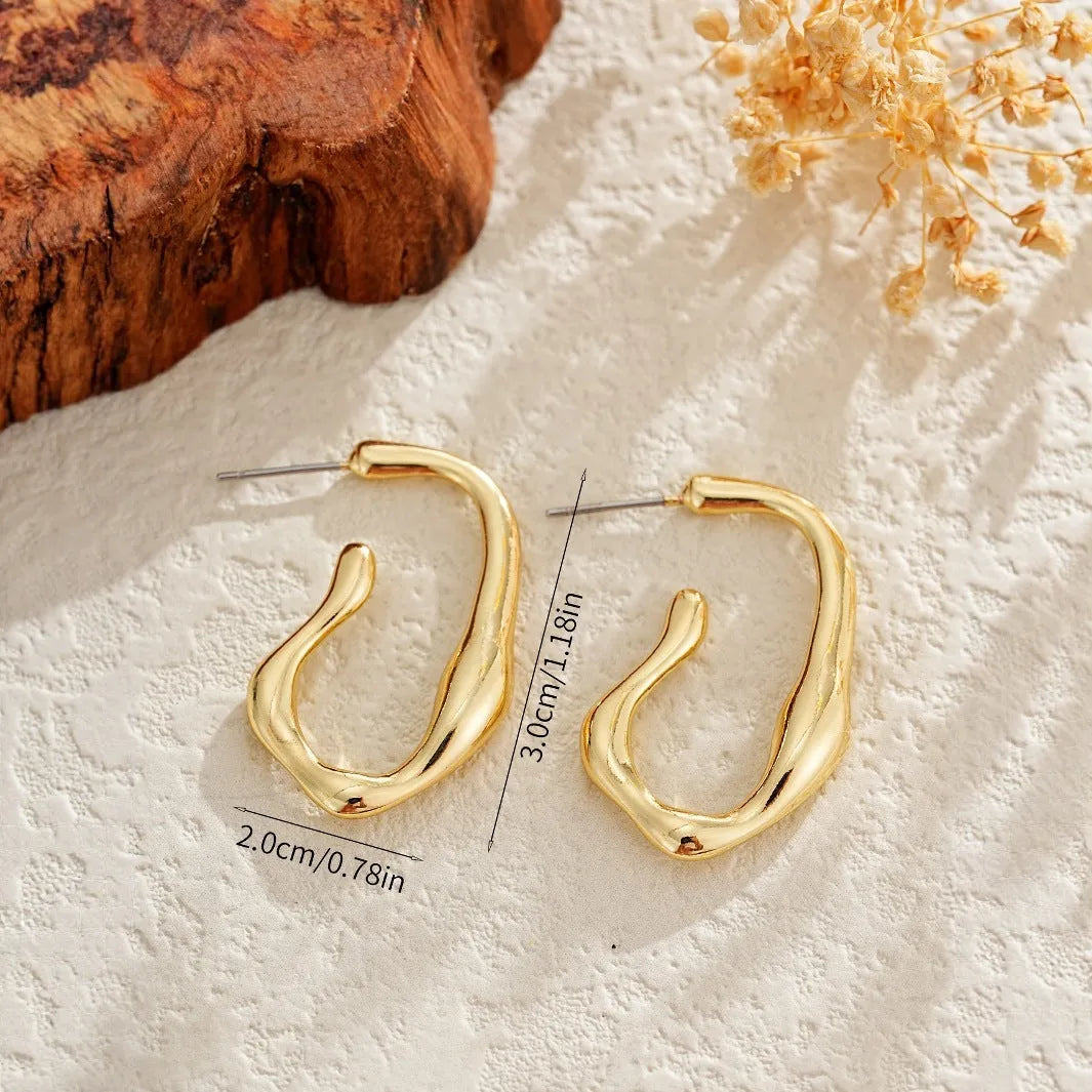 Irregular shaped minimalist gold dangle earrings for women on white background