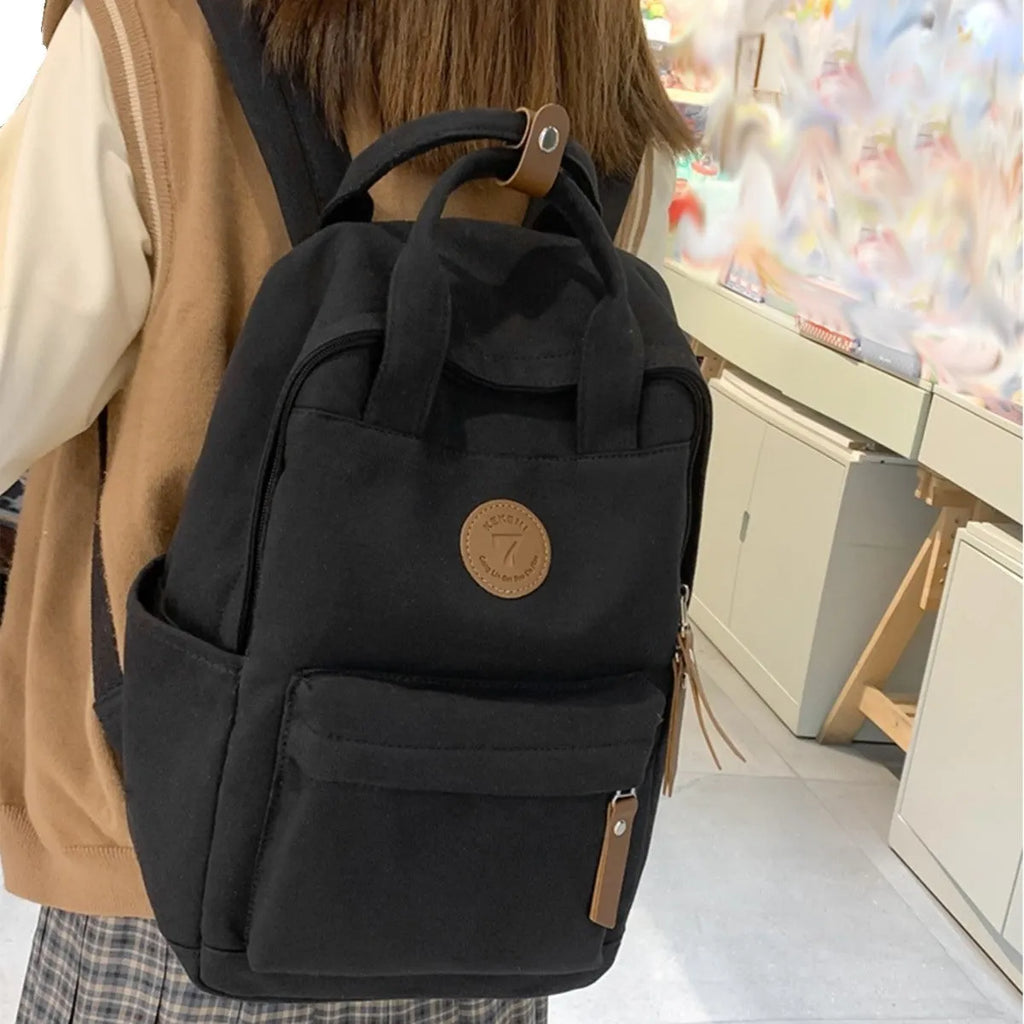 Black Oxford cloth backpack with curved shoulder straps and retro urban style detailing