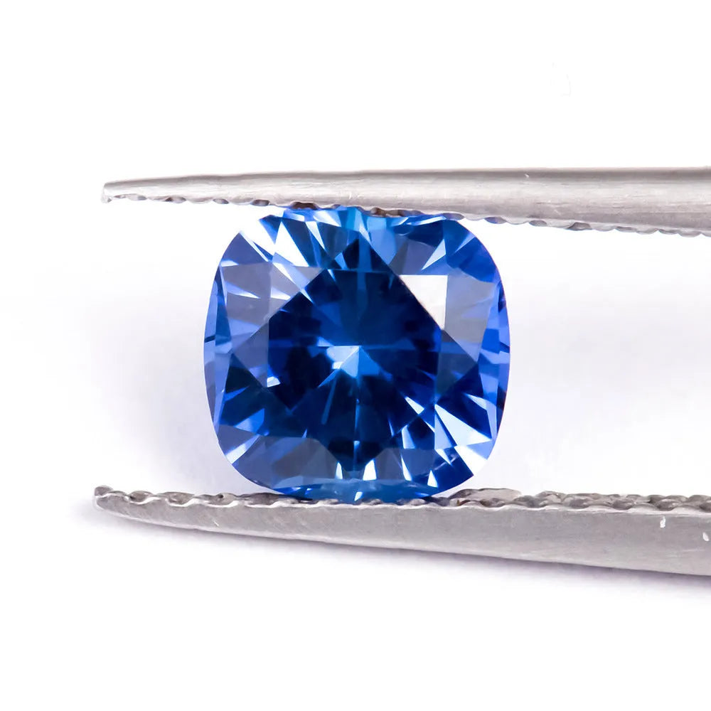 Royal blue loose gemstone in heart, round, and pear shapes on a white background.