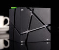 Cube Bluetooth Speaker with colourful lights in black ABS casing, front view on desk