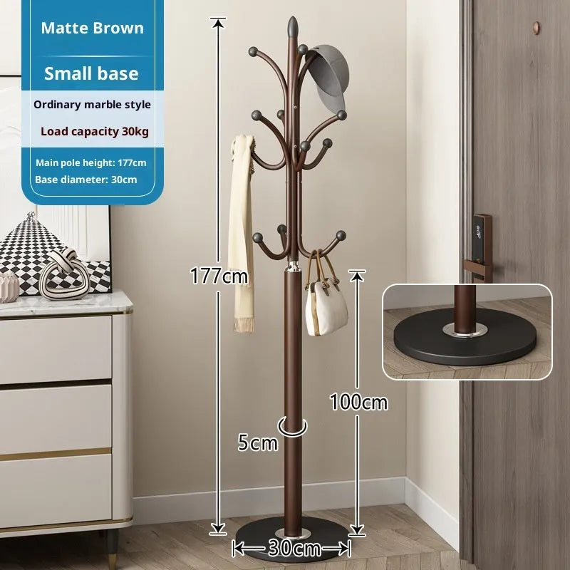 Floor-standing iron coat rack in black with vertical metal frame for hanging jackets and bags in a bedroom or hallway
