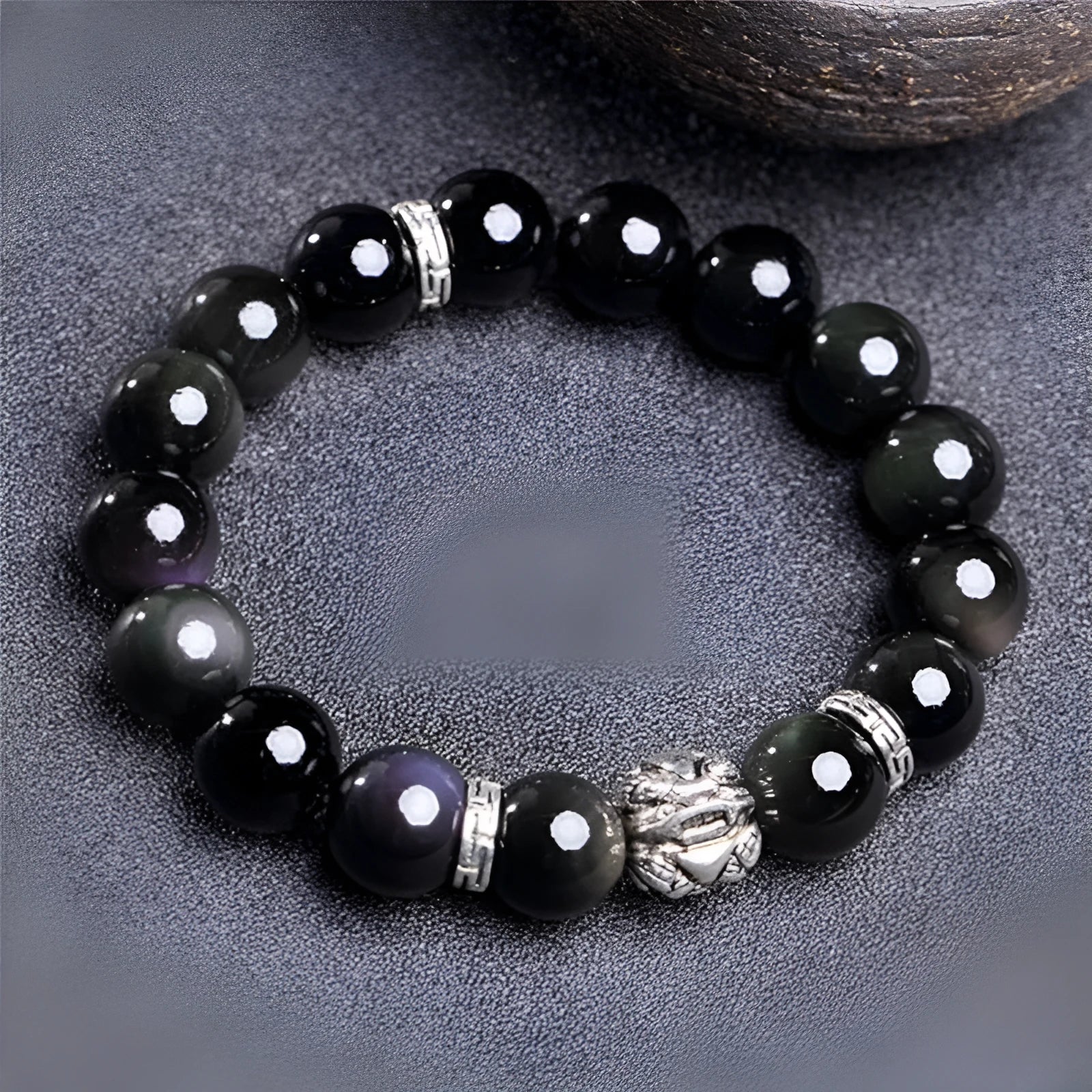 Natural obsidian bead bracelet with Silver 999 details and Cloud Year Of design on a wrist.