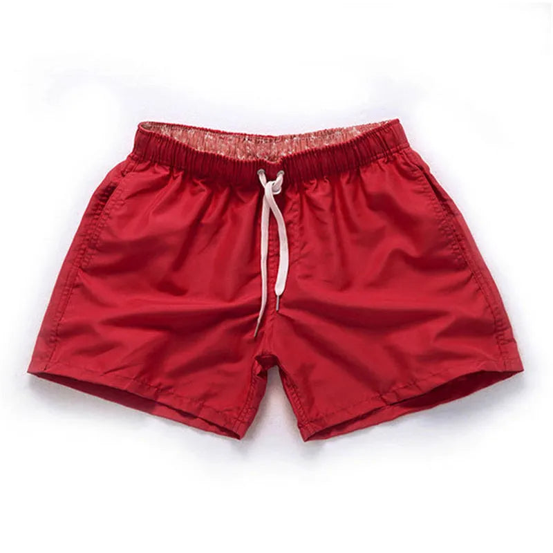 Men's straight-leg beach shorts in polyester, shown in a colour from the range including fluorescent yellow, black, or navy.