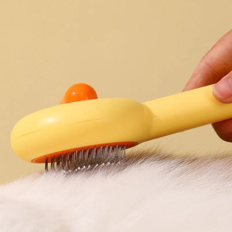 Small yellow plastic duck-shaped pet grooming comb with needle bristles.