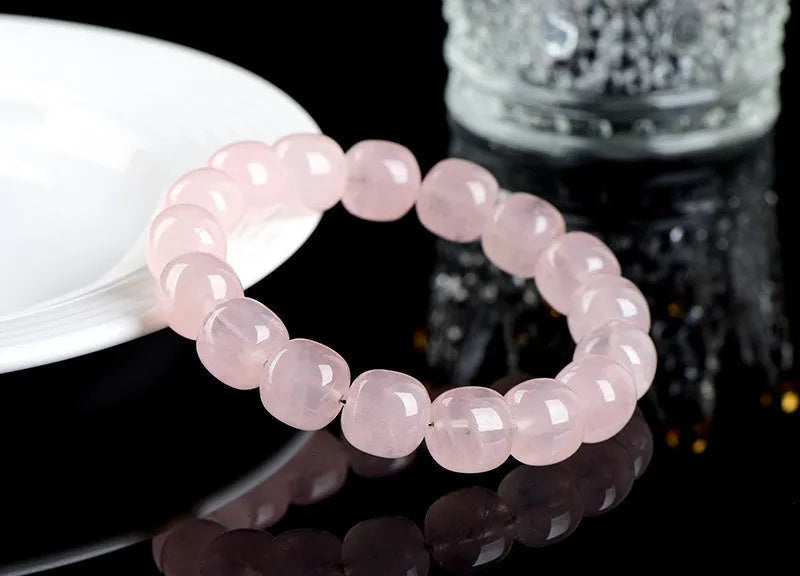 Pink crystal barrel bead bracelet with 11mm to 12mm geometric beads on natural background
