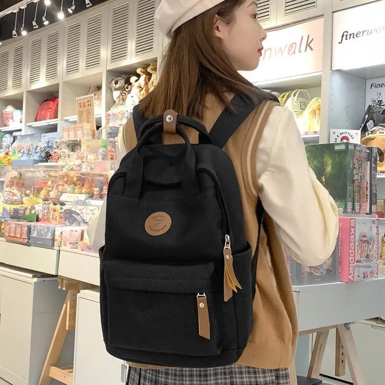 Black Oxford cloth backpack with curved shoulder straps and retro urban style detailing