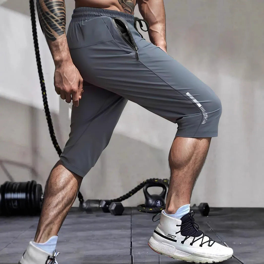 Men's grey ice silk cropped sports trousers with straight leg on a neutral background.