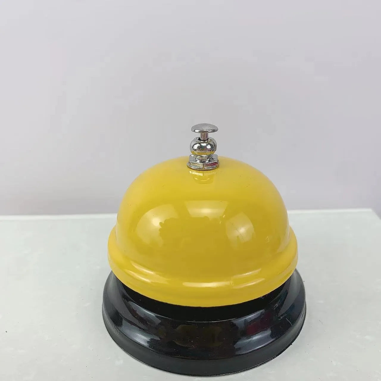 A multi-colour iron hand bell for games, classrooms, or restaurant service.