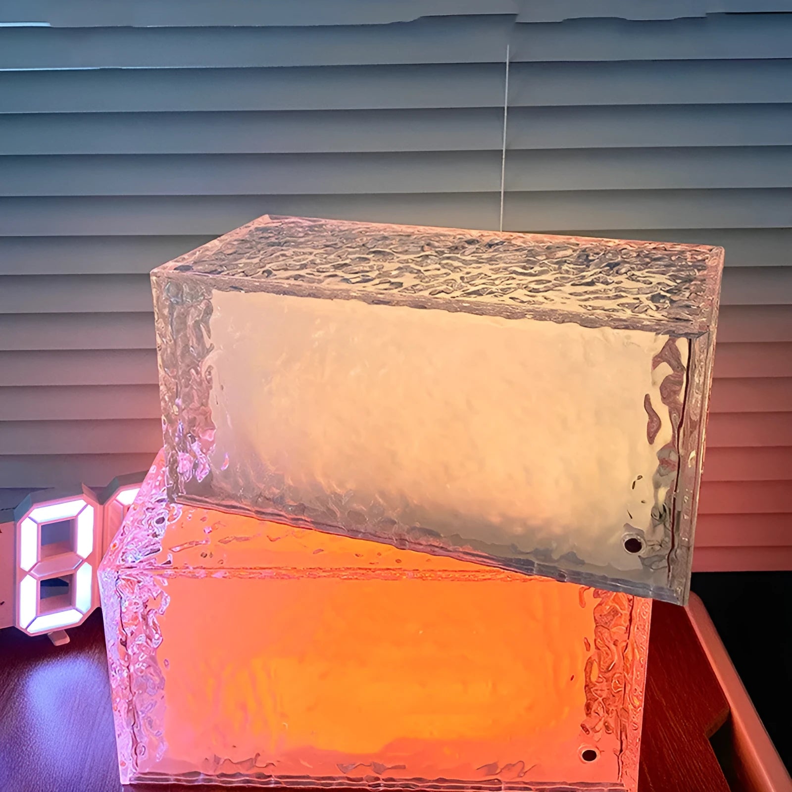 Small clear acrylic cube night light with colour-changing LED mood lighting on a wooden surface.