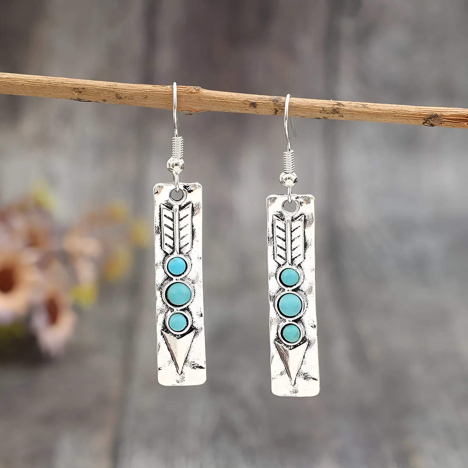 Geometric long silver earrings with blue turquoise inlay detail on a white background.