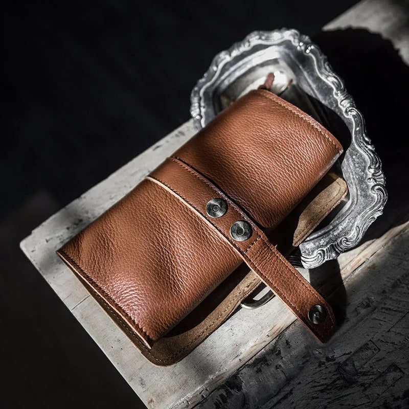 Handmade brown cow leather vintage wallet with tape closure, lying flat.