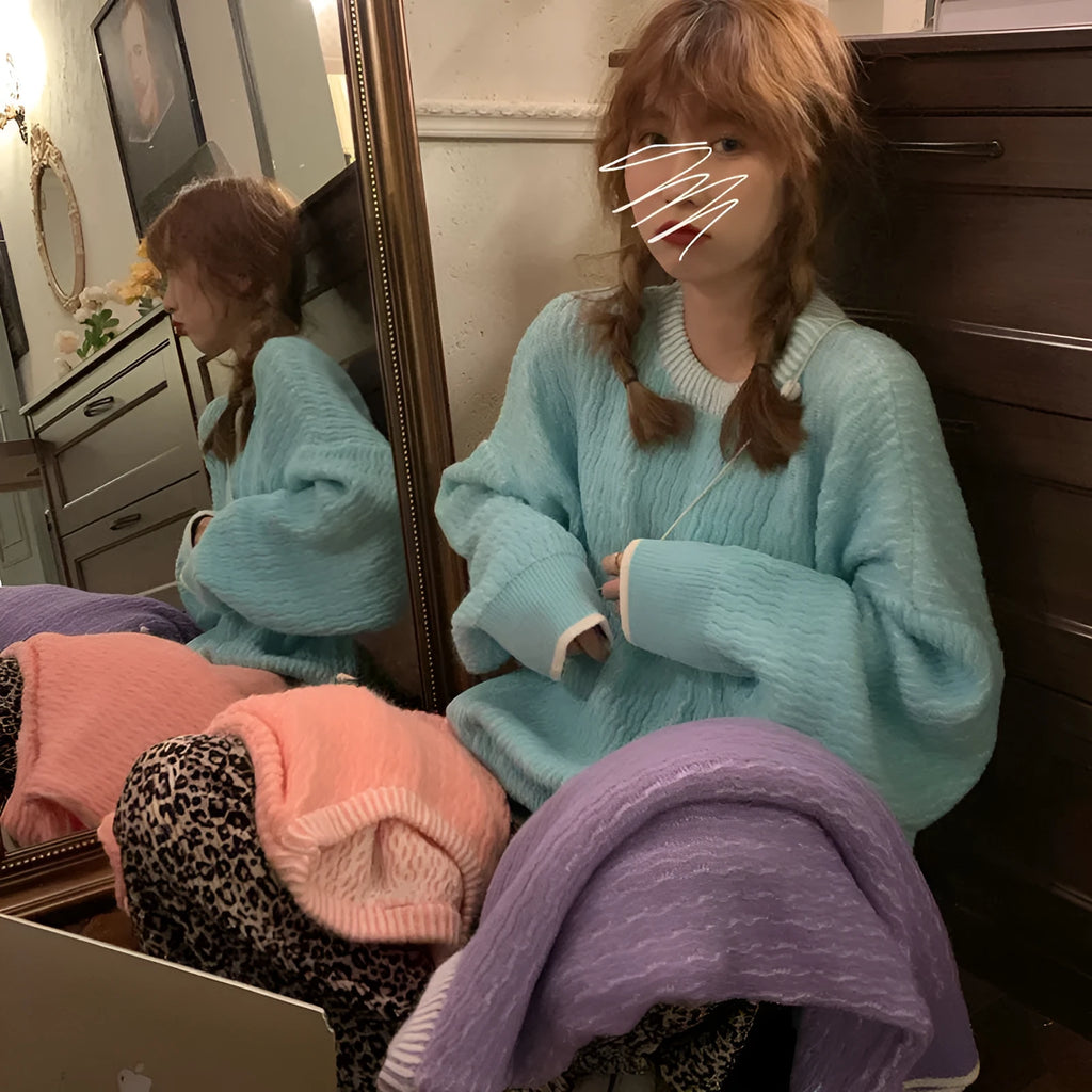 A woman's loose-fit solid colour pullover sweater in a retro style, shown in lake blue.