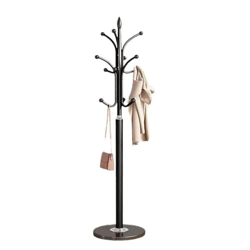 Floor-standing iron coat rack in black with vertical metal frame for hanging jackets and bags in a bedroom or hallway