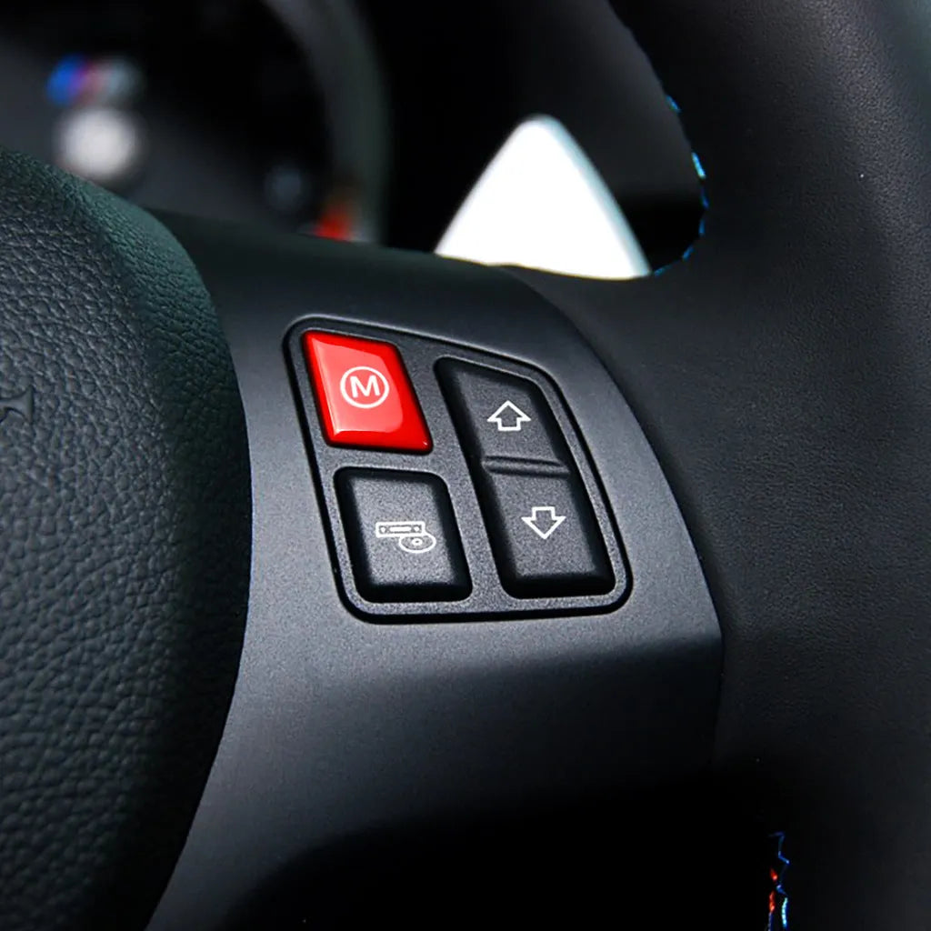 Red and blue BMW M1 M2 steering wheel button accessories with installation keys on a black background