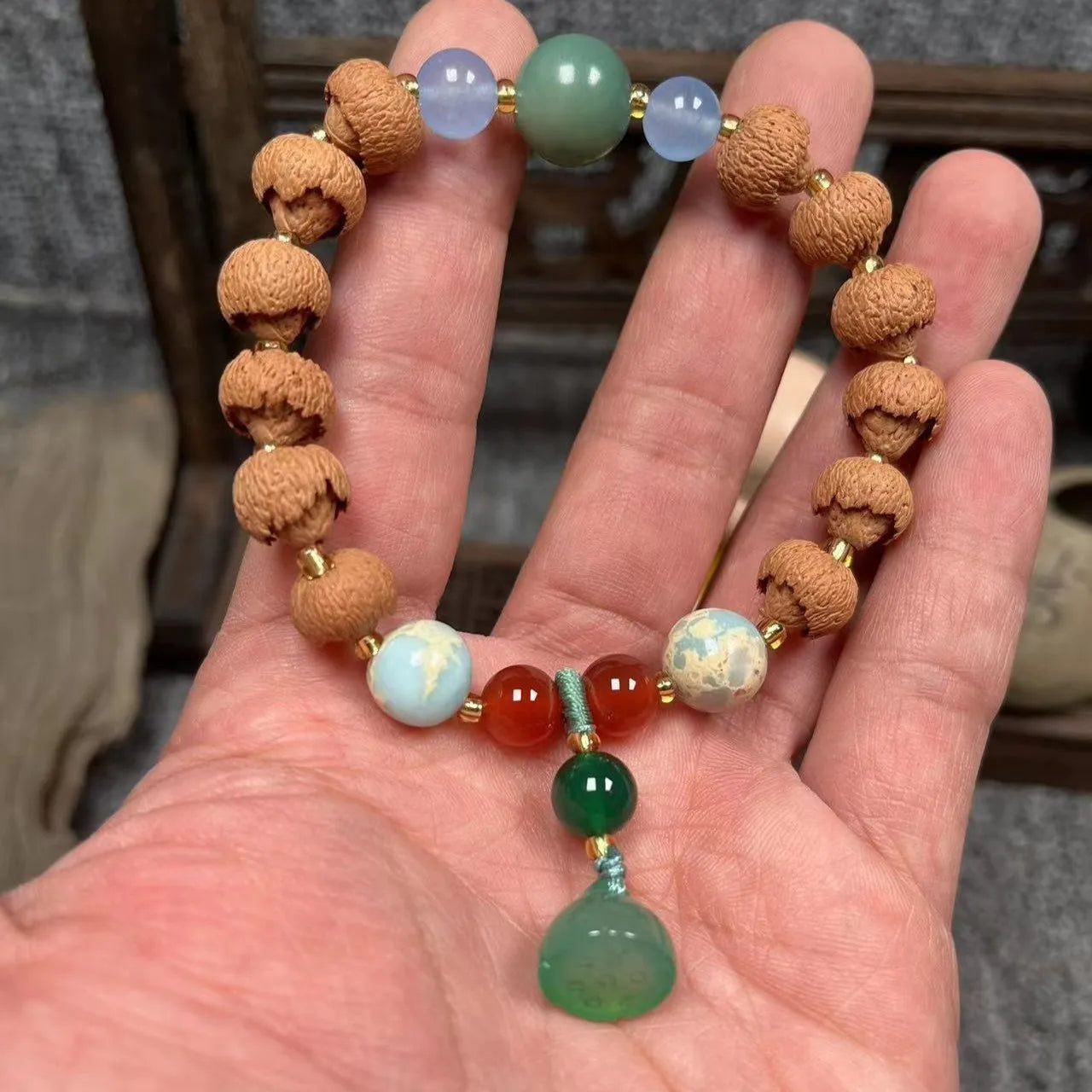 Carved pumpkin and lotus bead bracelet made from Bodhi root with white jade and aventurine details.