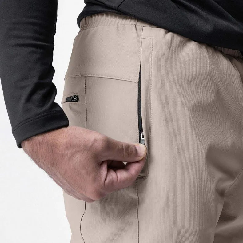 Men's grey loose-fit running pants with ankle ties on a gym floor