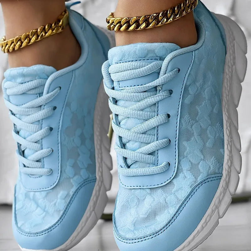 Women's white canvas casual running shoes with flat heel and round toe on a plain background.