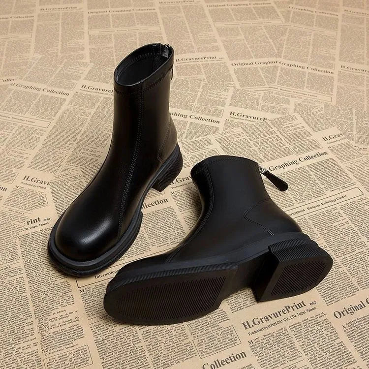 Women's black ankle boot with round toe, thick flat heel, and rear zipper on a rubber sole.