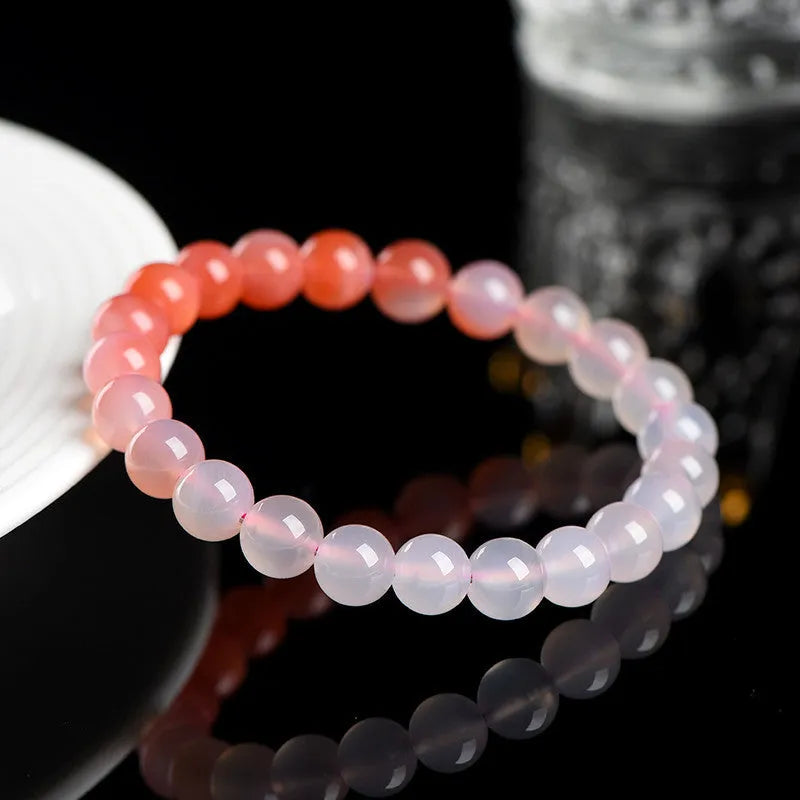 Natural gradient Yanyuan agate bracelet with spherical beads on a white background.