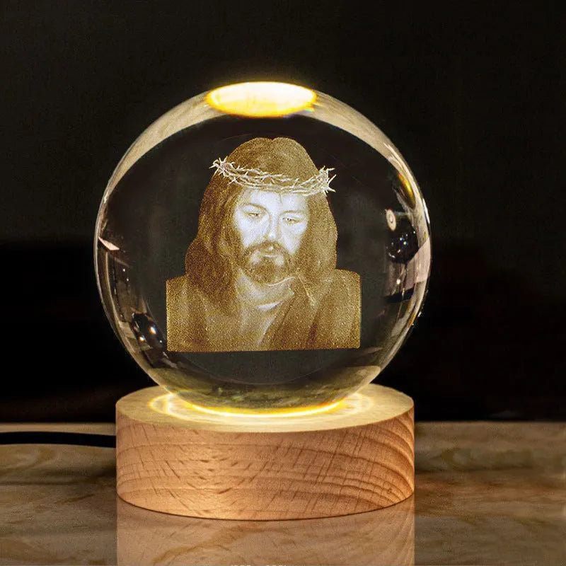 White crystal ball ornament on wood base with warm light and religious symbols