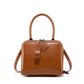 Open grain leather handbag in black with visible grain texture and welt pocket on front