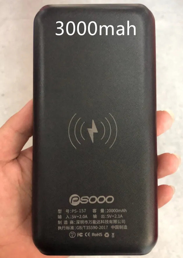 Portable power bank with wireless charging pad and three USB ports in black plastic casing