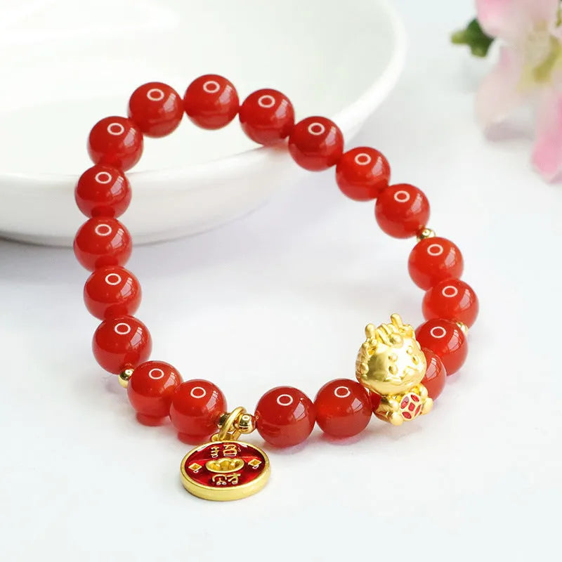 Close-up of a red agate beaded bracelet with a Chinese zodiac dragon charm on a wrist.