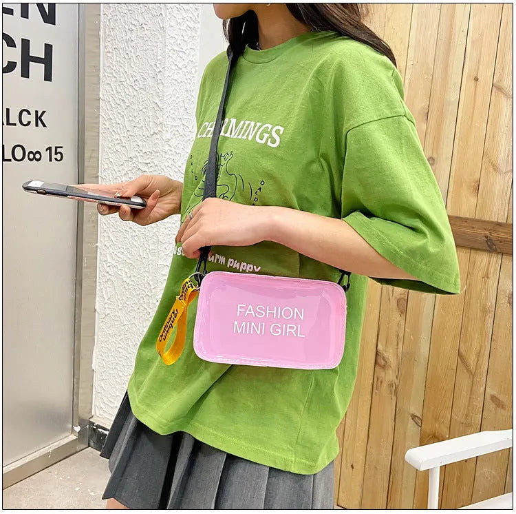 Transparent square women's shoulder bag in jelly material with a diagonal cross strap, showing internal mobile phone pocket.