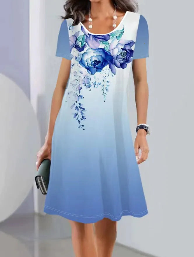 A model wearing a light blue botanical print midi dress with short sleeves and an A-line skirt.