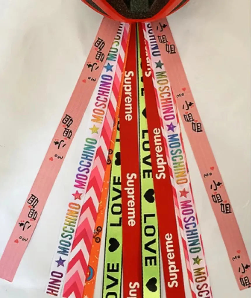 Colourful decorative ribbon streamers attached to a children safety helmet for skating or skiing