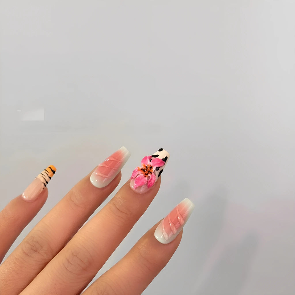 Close-up of hand-carved acrylic press-on nails with a Lily zebra pattern, floral, and leopard print design.