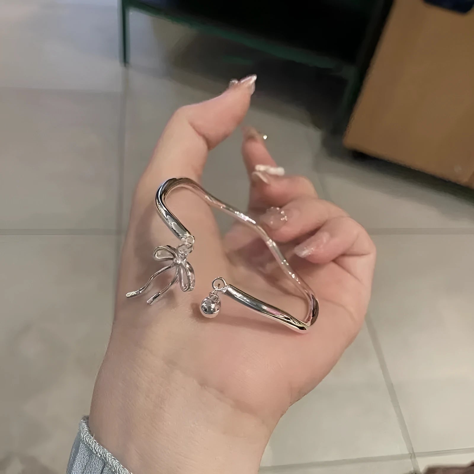 Silver bow adjustable women's bracelet with bell opening clasp in colour M1534