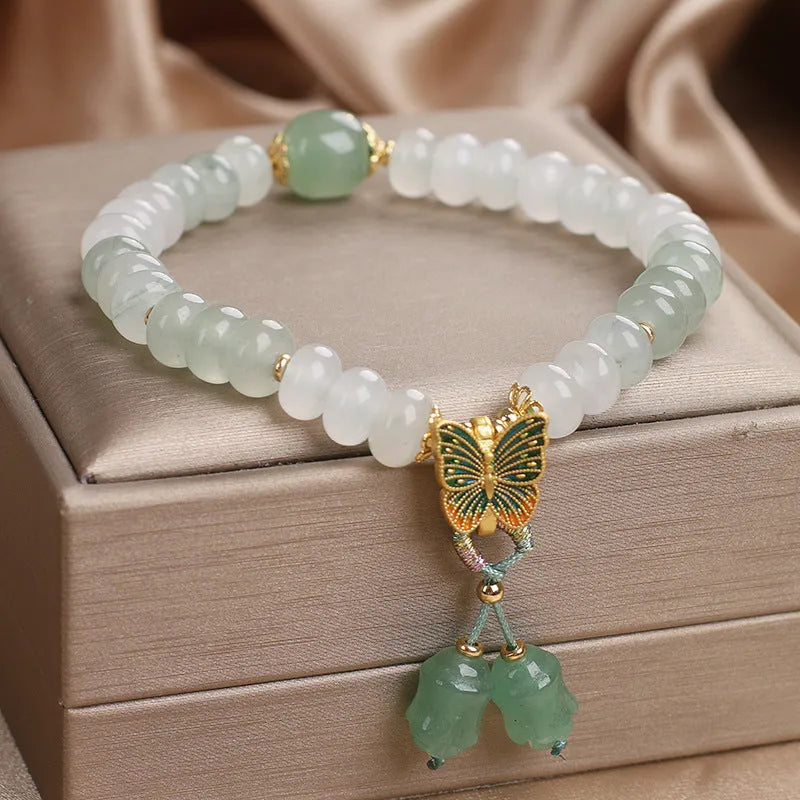 Green crystal Tian Shan Cui abacus bead bracelet with butterfly tassel, pearls and rhinestones.