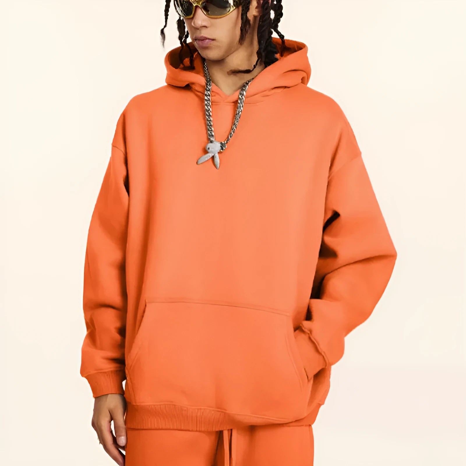 Man wearing a loose grey hooded terry cotton sweater with drop-shoulder sleeves.