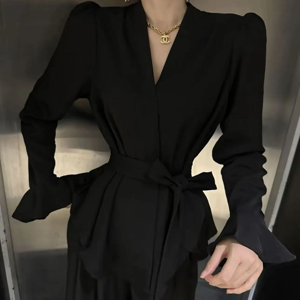 Women's black French-style shirt with irregular collar, long bell sleeves, and a front tie detail.