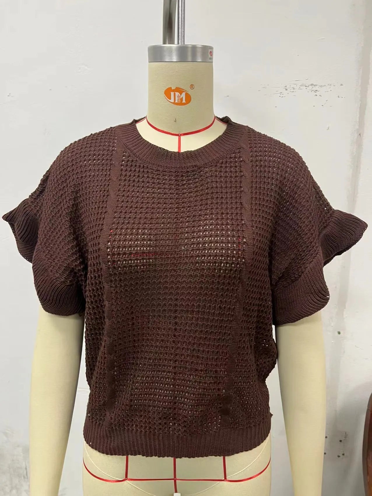 White knitted pullover sweater with ruffled short sleeves created from twisted string, shown in a loose fit.