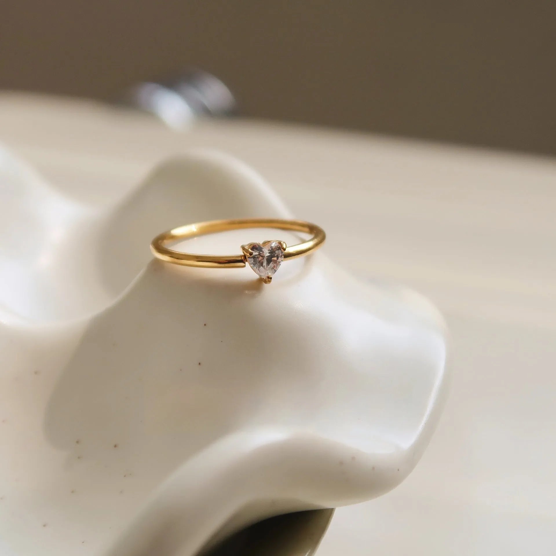 Golden stainless steel ring showing love heart and oval design options on a white background.