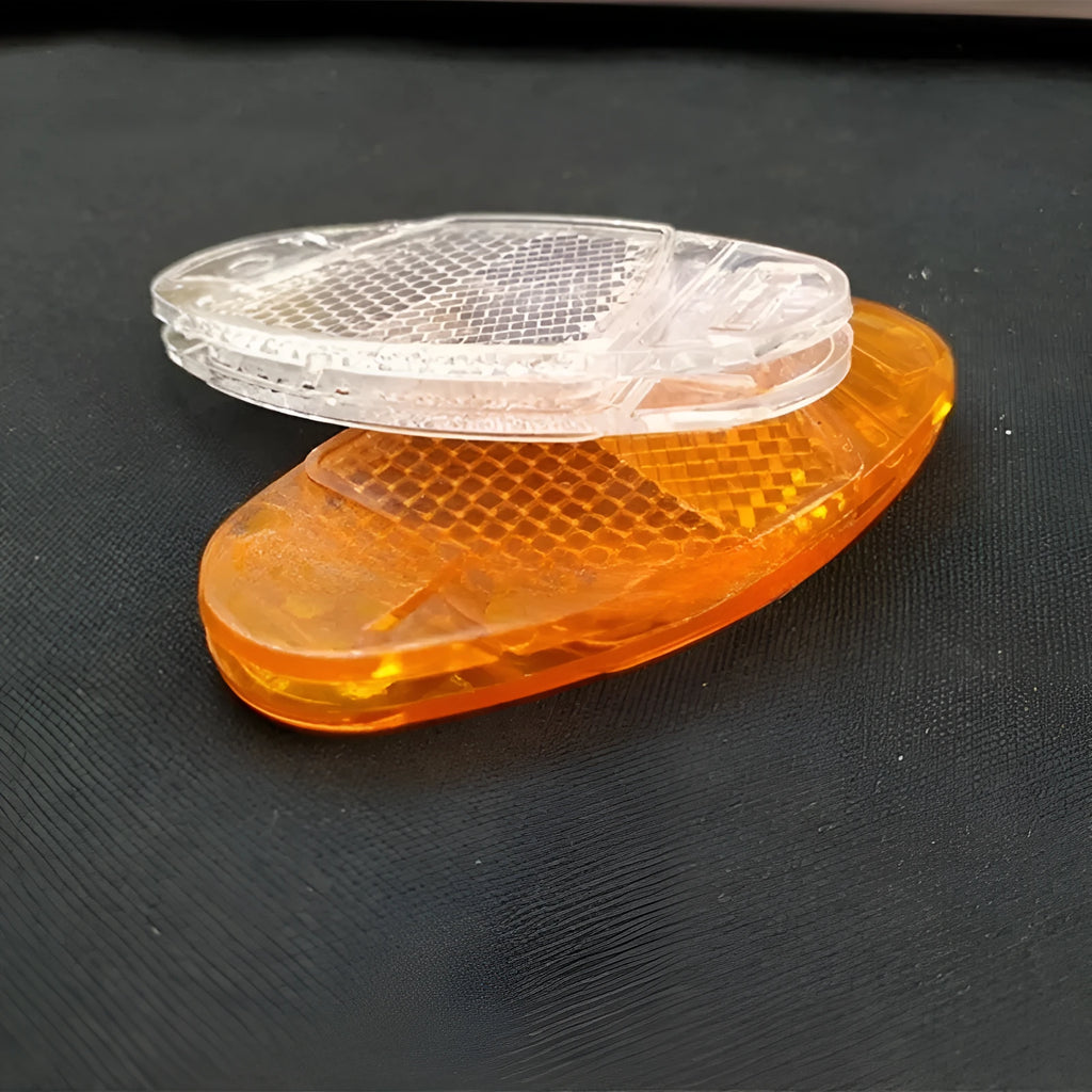 Bicycle spoke reflector showing yellow plastic construction with clip-on attachment for wheel safety