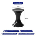Plastic hourglass-shaped shoe changing stool in selected colour, shown in a home entryway setting.