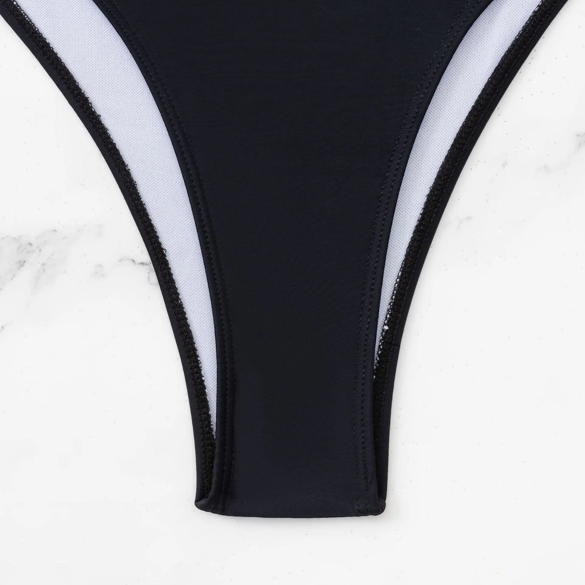 Black one-piece swimsuit with white contrast stitching and hollow cut-out details, front view, sleeveless design