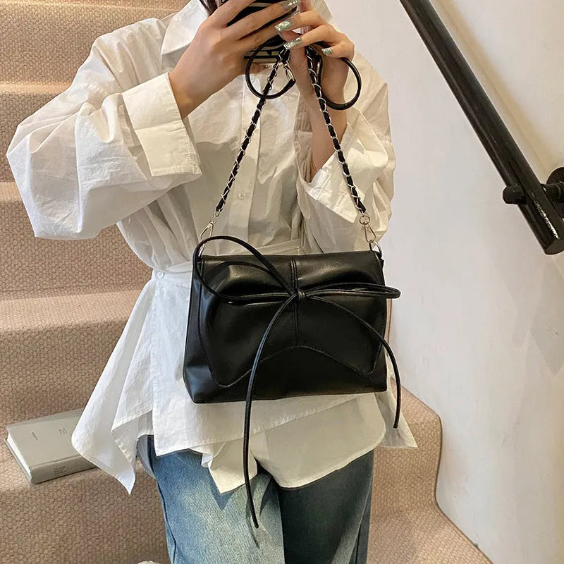 Women's black PU leather crossbody bag with horizontal square shape and visible sewing details