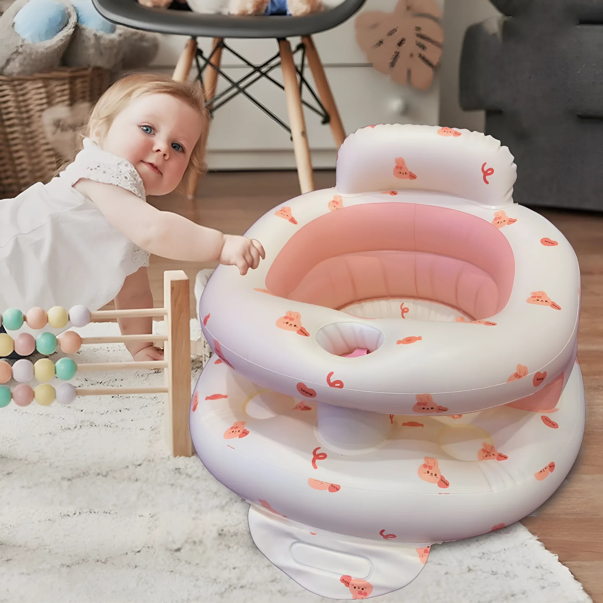 Inflatable infant dining chair in PVC with bear design, deflated beside a baby for scale